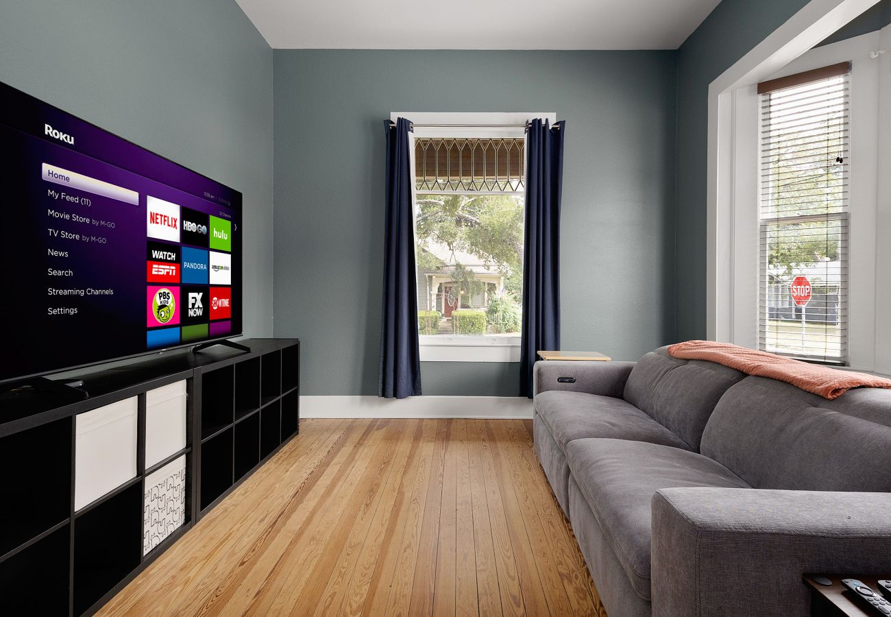 Media room large smart TV gray convertible sofa, wood floors in Seguin vacation rental